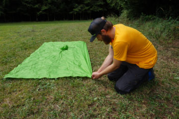 Abbildung 1: Spanne die lange, dem Wind zugewandte Seite mit Heringen am Boden ab. | Foto: Flo Glott