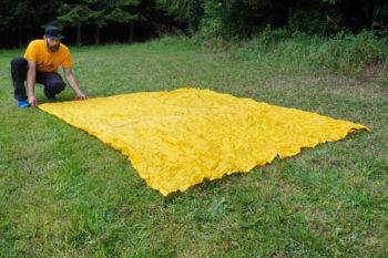 Abbildung 1: Breite dein Tarp auf dem Boden aus. Hier sollte eine kurze Seite dem Wind zugewandt sein. | Foto: Flo Glott