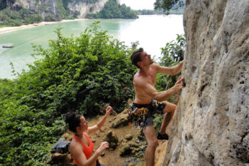 Eine Person klettert und eine andere steht unterhalb, um zu sichern.