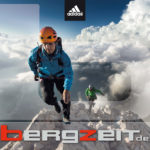 ein Bergsteiger läuft einen felsigen Grat entlang in adidas-Kleidung