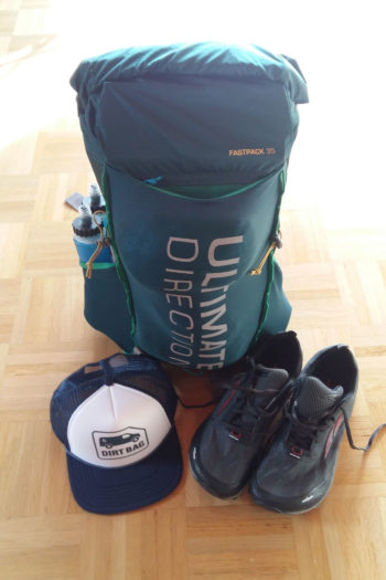 Fertig gepackter Rucksack mit Cap und Wanderschuhen davor