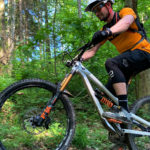 Mountainbiker von Seite fotografiert auf Uphill im Wald