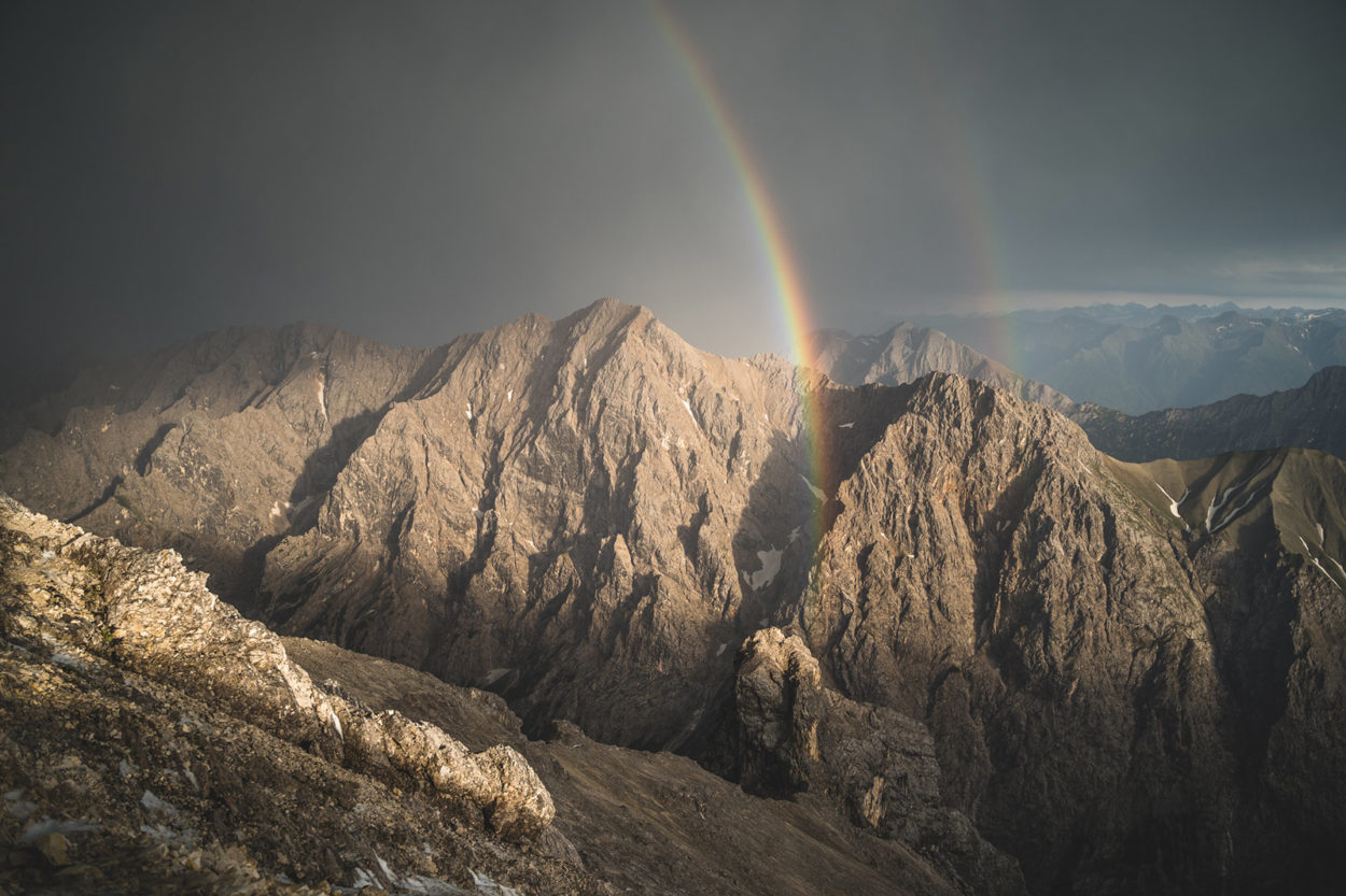 Regenbogen über Felsmassiv