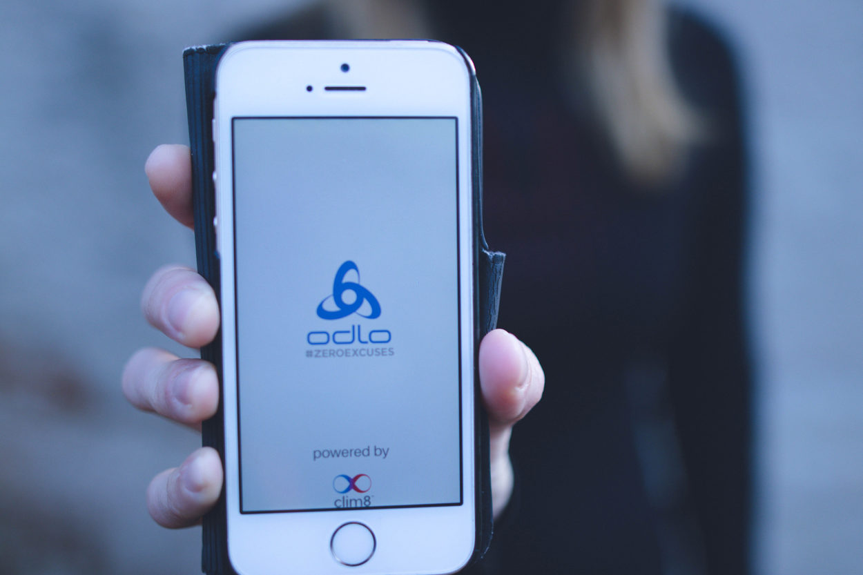 Frau hält Smartphone in die Kamera mit Odlo App