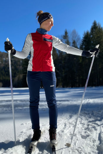 Langläuferin neben der Loipe mit Jacke und Hose von Swix